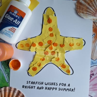 A childrens craft of a yellow starfish made from torn paper and orange paint dots on white paper, with a bottle of glue, orange paint, a brush, and seashells nearby. Text reads STARFISH WISHES FOR A BRIGHT AND HAPPY SUMMER!.