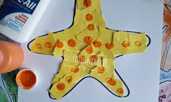 A childrens craft of a yellow starfish made from torn paper and orange paint dots on white paper, with a bottle of glue, orange paint, a brush, and seashells nearby. Text reads STARFISH WISHES FOR A BRIGHT AND HAPPY SUMMER!.