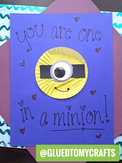 Handmade cupcake liner card with a playful Minion design on purple paper. Features “You are one in a minion!” and fun details like a googly eye, black strip, and smile. Perfect for card crafts fans! @GLUEDTOMYCRAFTS at the bottom.
