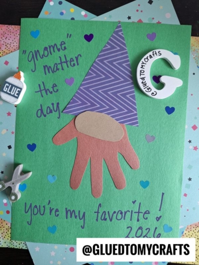 A colorful handmade card features a gnome with a zigzag purple hat and a brown handprint as the beard on green paper, surrounded by heart shapes—perfect for HANDPRINT FATHER'S DAY! The text reads: “gnome matter the day you’re my favorite! 2024.”.