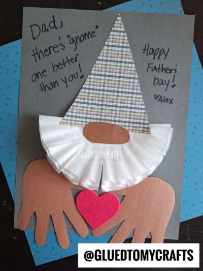 A handmade HANDPRINT FATHER'S DAY card shaped like a gnome, with a plaid hat, paper beard, brown hands holding a red heart, and the message: “Dad, there’s ‘gnome’ one better than you! Happy Father’s Day! ♥ Alex.”.