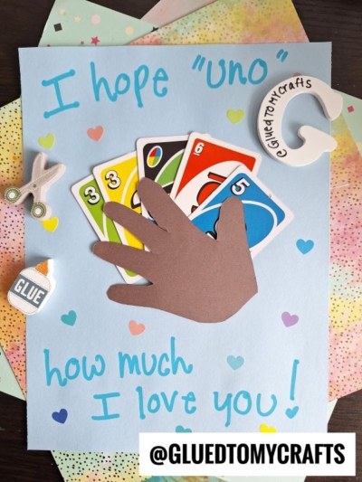 A handmade HANDPRINT FATHER'S DAY card features a child's brown handprint holding UNO cards, with the text "I hope UNO how much I love you!" surrounded by hearts, paper scissors, glue, and a craft logo.
