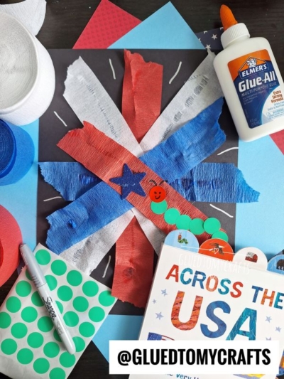 A festive 4th of July craft features red, white, and blue crepe paper strips in an X shape on black paper, surrounded by a glue bottle, green dot stickers, a Sharpie, and the book “Across the USA.” @GLUEDTOMYCRAFTS is labeled.