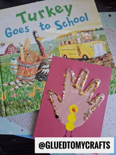 A children’s book titled “Turkey Goes to School” featuring a pink handprint turkey craft, decorated with sequins and yellow paper circles for the face and body—a perfect back to school keepsake. @GLUEDTOMYCRAFTS is written at the bottom.