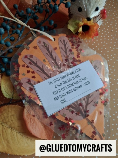 A handmade autumn leaf card with a poem, surrounded by orange leaves, a small hedgehog figurine, and decorative berries. The Instagram handle @GLUEDTOMYCRAFTS is visible at the bottom.