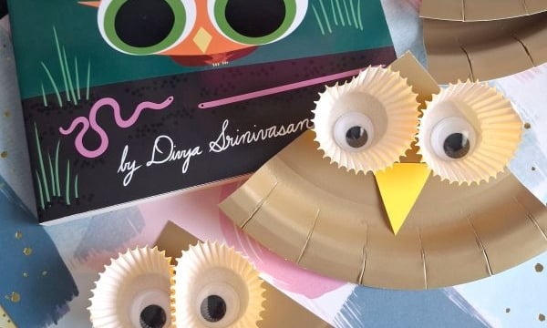 Children’s book “Little Owl’s Opposites” next to two owl crafts made from paper plates, googly eyes, and cupcake liners. Glue sticks and colored paper are also visible. @GLUEDTOMYCRAFTS watermark is over the image.