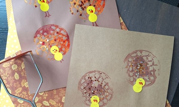 Two pieces of brown paper show turkey crafts made from painted potato masher prints for feathers and yellow paper for bodies, with craft supplies visible nearby. @GLUEDTOMYCRAFTS is written at the bottom.