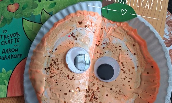 A peach-themed kids craft made from a paper plate with googly eyes and glitter sits on a table, next to the book Everything Is Peachy Keen. Instagram handle @GLUEDTOMYCRAFTS is shown.