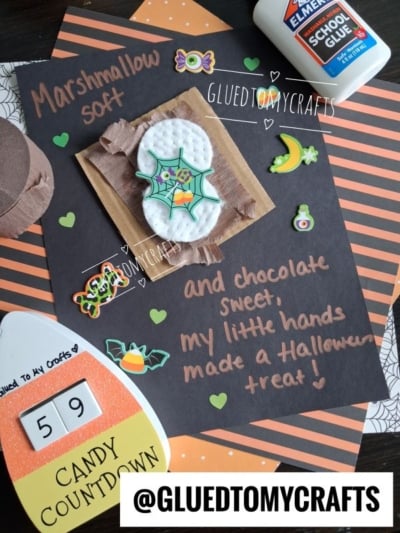 A Halloween-themed craft project with marshmallows and chocolate on paper, decorated with stickers, glue, and handwritten text about making a Halloween treat. Perfect for those searching for creative Halloween Crafts for Kids, this activity also features a candy countdown and @gluedtomycrafts is shown.