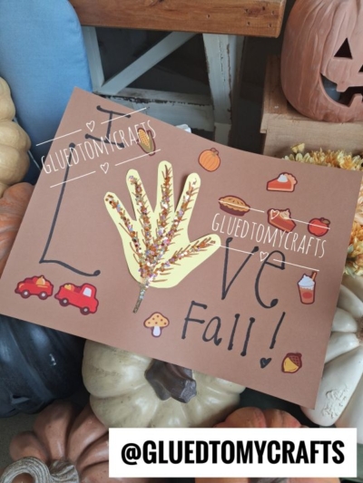 A fall-themed craft with a handprint tree, leaves, pumpkins, acorns, cars, and I Love Fall! written on brown paper, surrounded by pumpkins. This adorable project is perfect for those searching for fun and creative FALL CRAFTS FOR KIDS. Text overlay: @GLUEDTOMYCRAFTS.