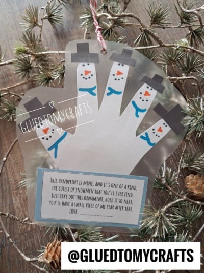 A laminated handprint ornament with fingers decorated as snowmen, featuring a poem about keeping a small piece of the childs year.