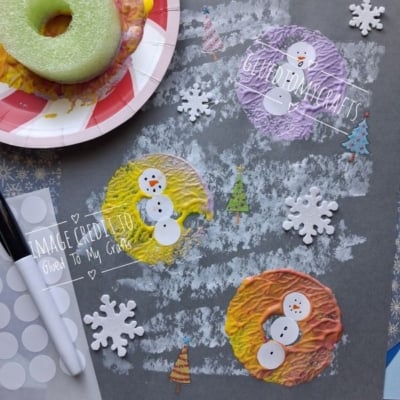 Three snowmen made from painted pool noodle prints on grey paper, decorated with foam snowflakes and small tree cutouts.