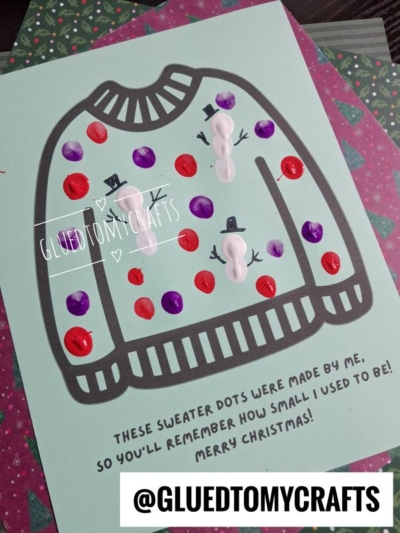 A handmade Christmas card featuring a gray sweater outline decorated with thumbprint snowmen and colorful paint dots, with the text: These sweater dots were made by me, so youll remember how small I used to be! Merry Christmas!.